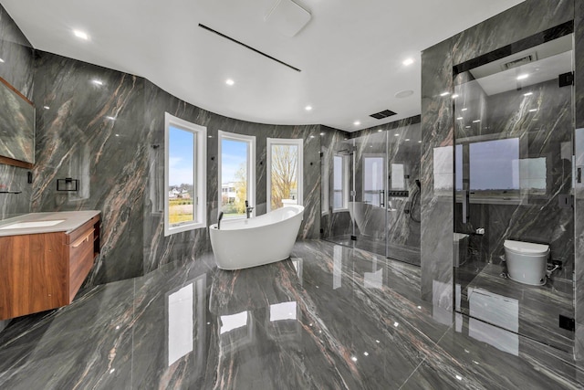bathroom featuring a freestanding tub, tile walls, vanity, toilet, and marble finish floor