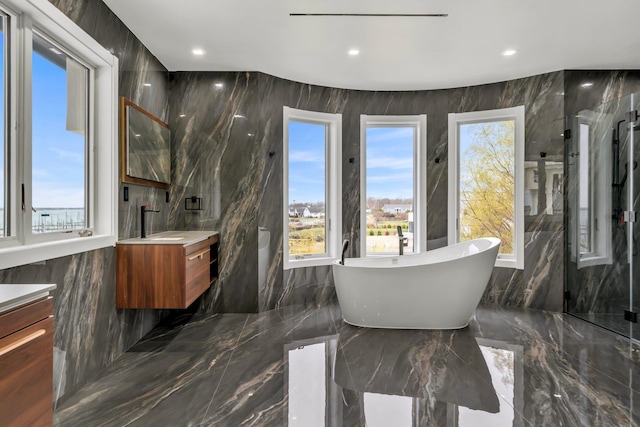 full bathroom featuring vanity, recessed lighting, marble finish floor, and a freestanding tub