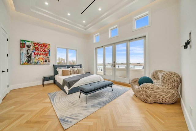 bedroom featuring baseboards, multiple windows, a high ceiling, and access to exterior