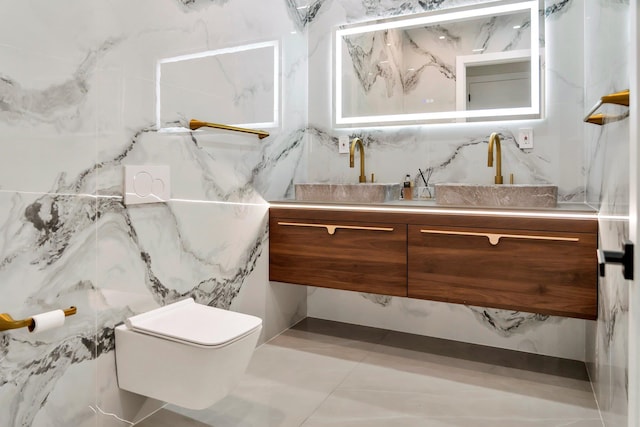 bathroom with a sink, tile walls, toilet, and double vanity