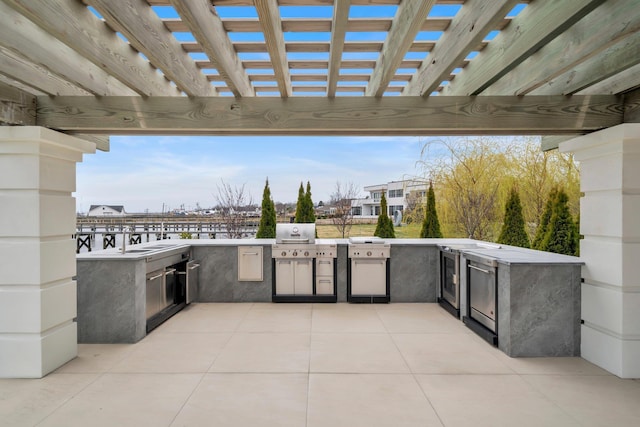 view of patio featuring exterior kitchen, a pergola, and a grill