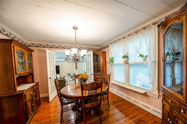 405 Linden St, Bellmore, NY 11710 - dining room with a baseboard radiator, a wall unit AC, a chandelier, and hardwood / wood-style floors