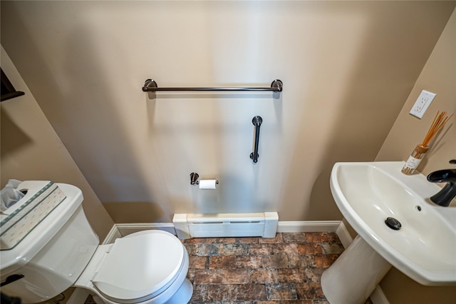 405 Linden St, Bellmore, NY 11710 - bathroom with stone finish flooring, baseboard heating, a sink, baseboards, and toilet