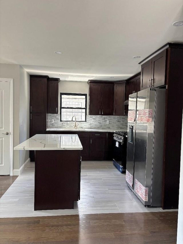 177-37 115th Ave, Saint Albans, NY 11434 - kitchen with appliances with stainless steel finishes, dark brown cabinetry, a kitchen island, decorative backsplash, and recessed lighting