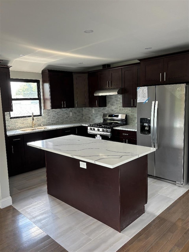 177-37 115th Ave, Saint Albans, NY 11434 - kitchen with appliances with stainless steel finishes, a sink, under cabinet range hood, light wood-style flooring, and a kitchen island