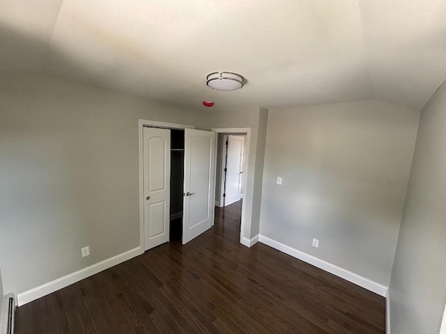 177-37 115th Ave, Saint Albans, NY 11434 - unfurnished bedroom with lofted ceiling, baseboards, dark wood finished floors, a closet, and baseboard heating