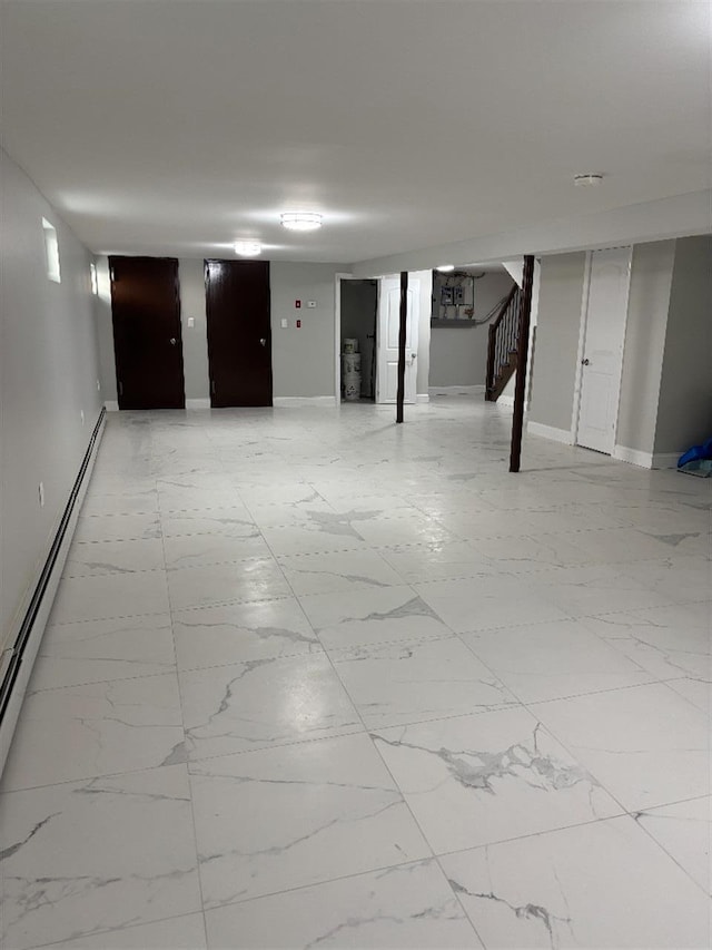 177-37 115th Ave, Saint Albans, NY 11434 - finished below grade area with stairway, a baseboard heating unit, baseboards, and light marble finish flooring
