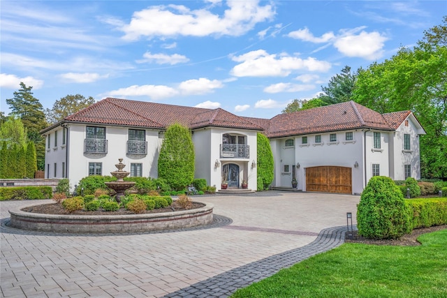 84 S Woods Rd, Woodbury, NY 11797 - mediterranean / spanish home with stucco siding, a tile roof, curved driveway, and a balcony