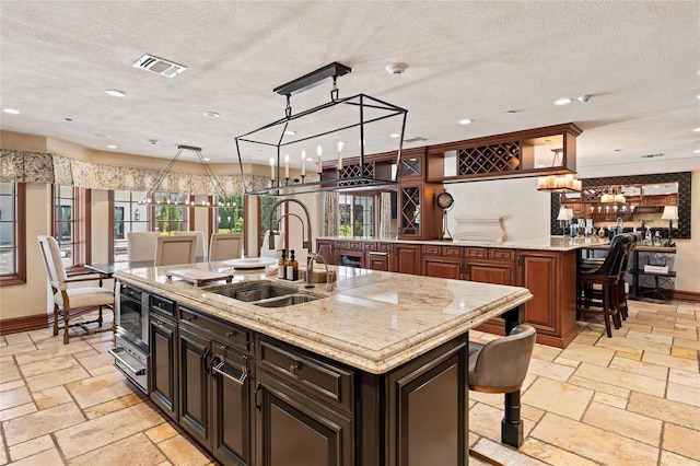 84 S Woods Rd, Woodbury, NY 11797 - kitchen with a sink, a kitchen bar, visible vents, and a center island with sink