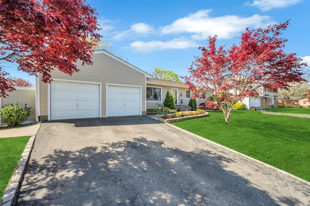view of front of property featuring a garage, a front lawn, and aphalt driveway