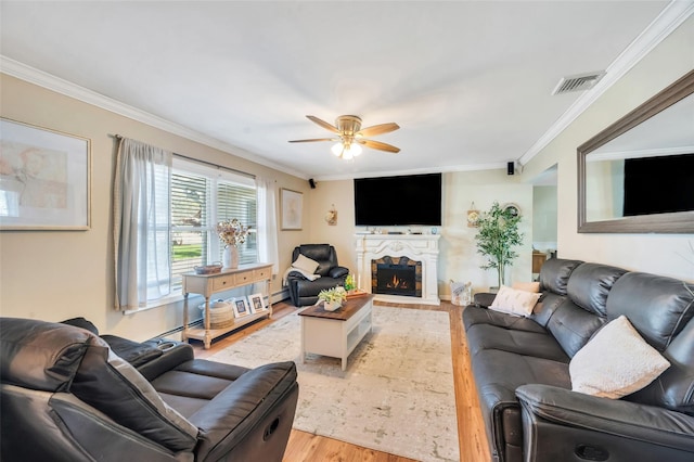 living area with ceiling fan, visible vents, a baseboard radiator, ornamental molding, and light wood-style flooring
