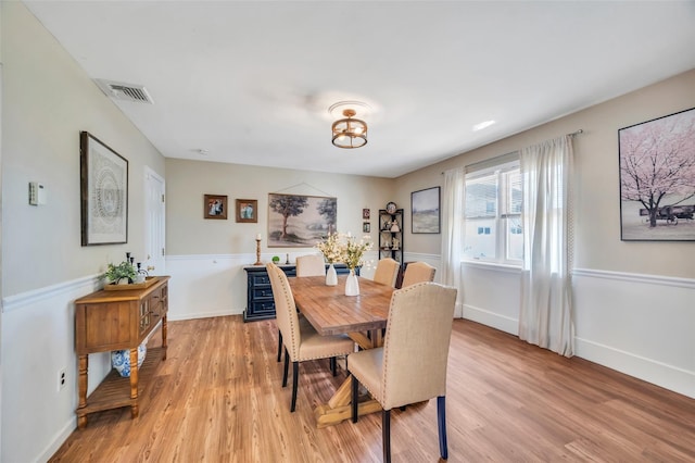 dining area with baseboards, visible vents, and light wood-type flooring