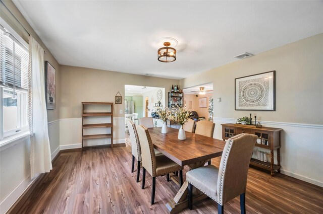dining area featuring baseboards, visible vents, and dark wood finished floors