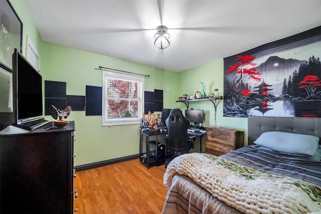 bedroom with baseboards and wood finished floors