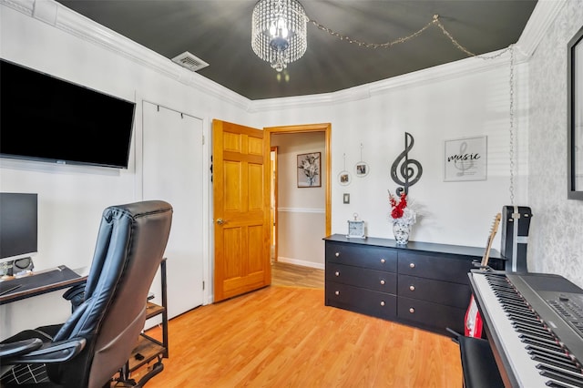 office with crown molding, an inviting chandelier, light wood-type flooring, and visible vents