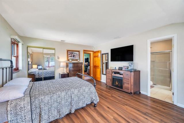 bedroom with a closet, dark wood finished floors, baseboards, and visible vents