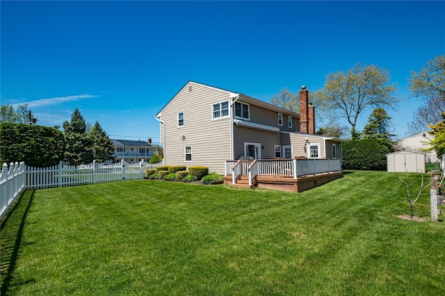 20 Bayview Rd, Amityville, NY 11701 - back of property featuring a storage shed, a chimney, a wooden deck, an outdoor structure, and a fenced backyard