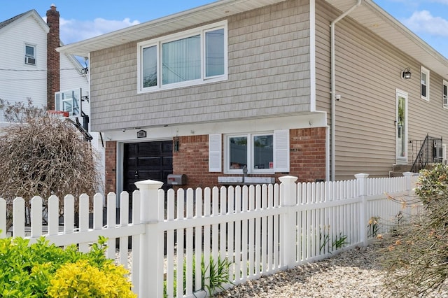 colonial-style house with brick siding and a fenced front yard