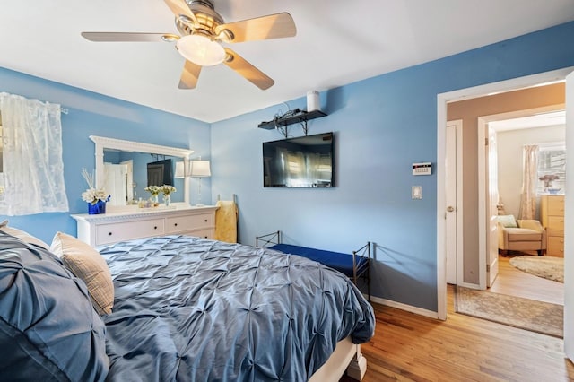 bedroom featuring light wood-style floors, baseboards, and a ceiling fan