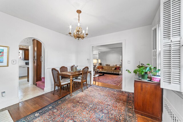 50 Oakland Ave, Tuckahoe, NY 10707 - dining room with light wood finished floors, a chandelier, baseboards, and arched walkways