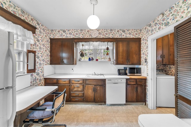 50 Oakland Ave, Tuckahoe, NY 10707 - kitchen featuring a sink, wallpapered walls, white appliances, washer / dryer, and light countertops