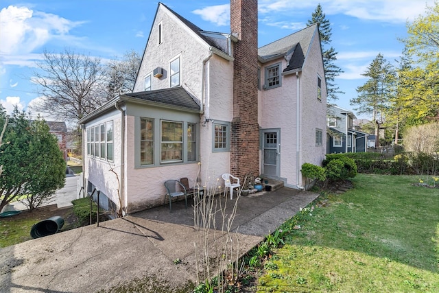 50 Oakland Ave, Tuckahoe, NY 10707 - rear view of property with stucco siding, a chimney, a lawn, and a patio area