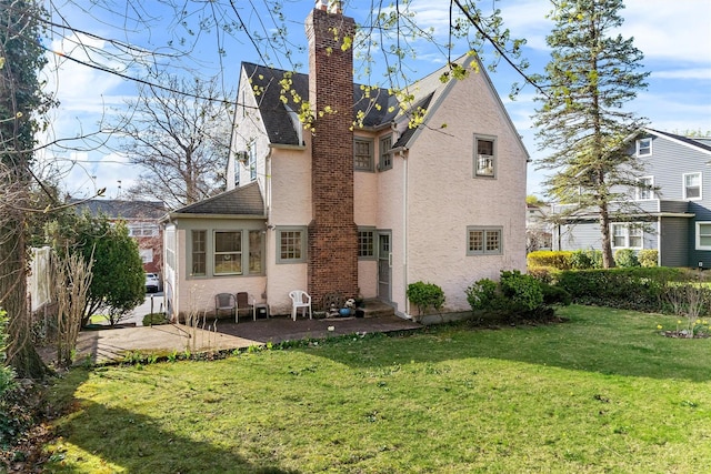 50 Oakland Ave, Tuckahoe, NY 10707 - rear view of property featuring roof with shingles, a patio area, a yard, stucco siding, and a chimney