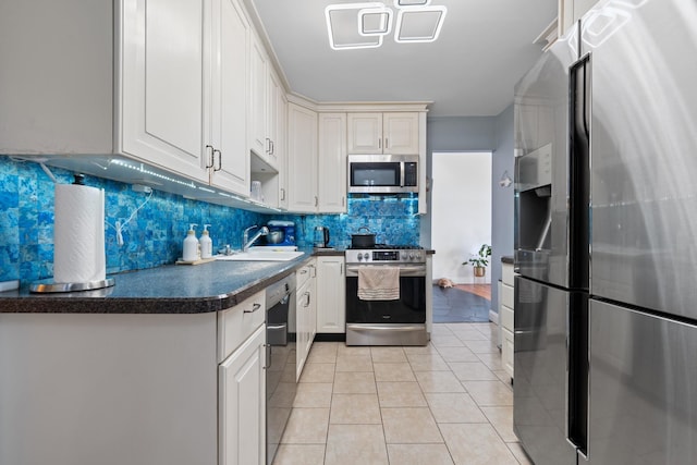 299 Whitman Dr, Brooklyn, NY 11234 - kitchen with dark countertops, appliances with stainless steel finishes, a sink, decorative backsplash, and light tile patterned floors