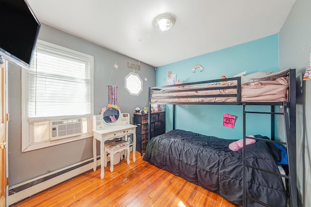 bedroom with baseboard heating, wood-type flooring, and cooling unit