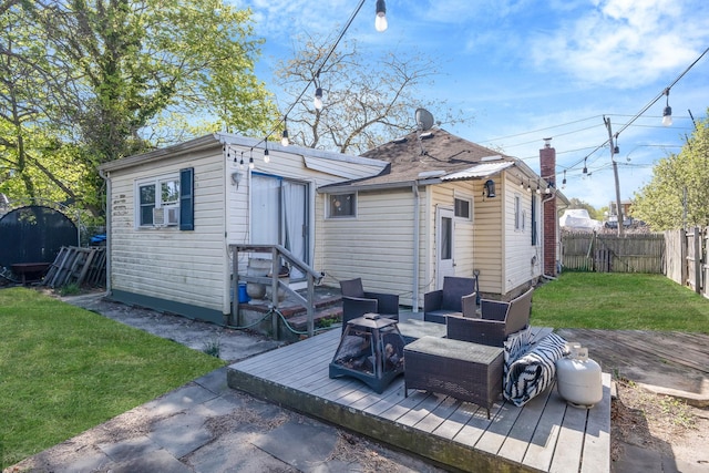 rear view of house with a lawn, a wooden deck, a fenced backyard, an outdoor living space with a fire pit, and entry steps