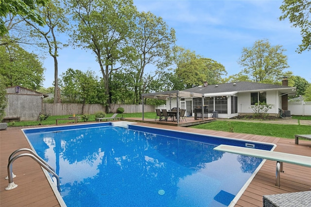 view of swimming pool with a wooden deck, outdoor dining space, a pergola, and a storage unit