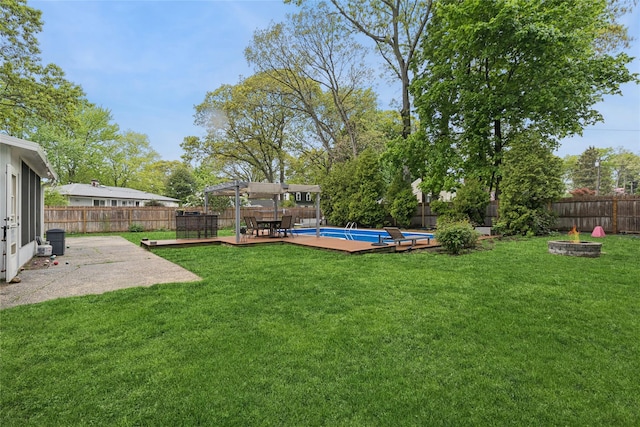 view of yard featuring a pergola, a fire pit, a deck, and a patio