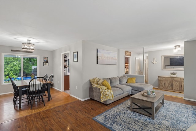 living area with a chandelier, wood finished floors, and baseboards