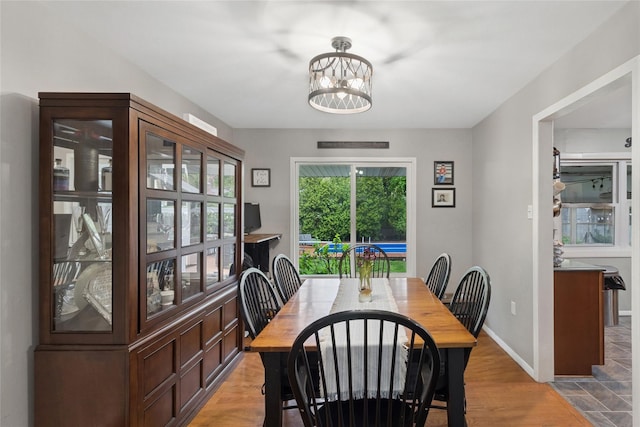 dining area with a chandelier and baseboards