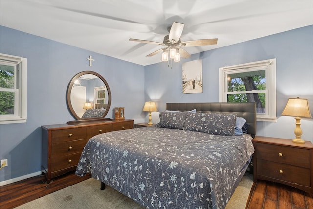 bedroom featuring wood finished floors, baseboards, and a ceiling fan