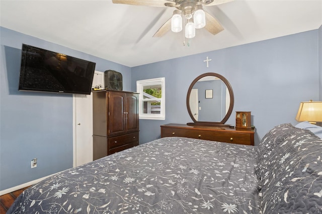 bedroom featuring wood finished floors, ceiling fan, and baseboards