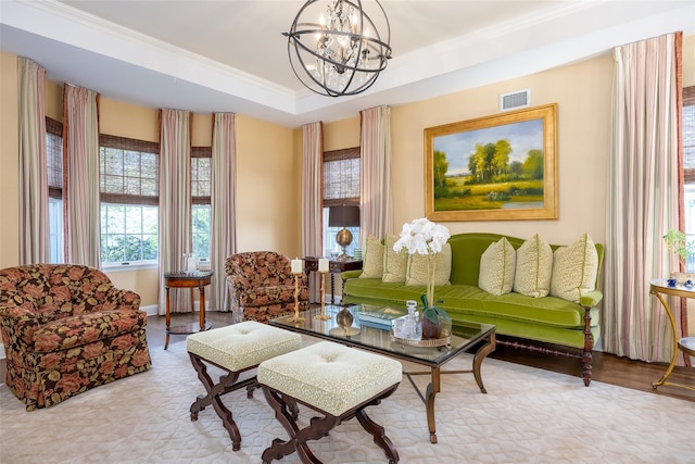 sitting room featuring a notable chandelier, a raised ceiling, baseboards, visible vents, and ornamental molding