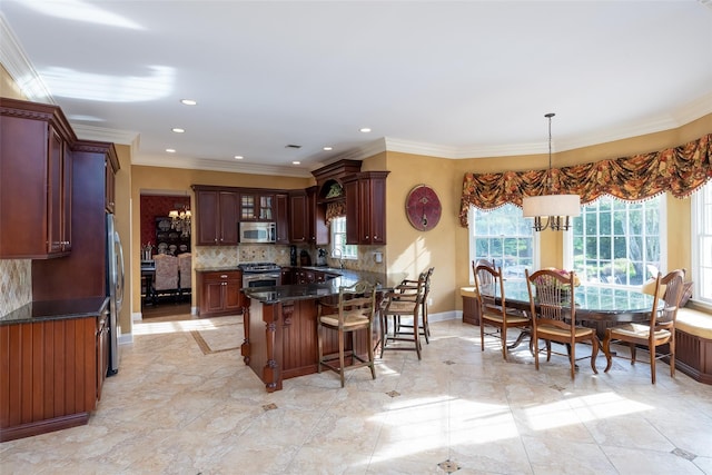 kitchen featuring a breakfast bar, tasteful backsplash, a sink, appliances with stainless steel finishes, and a notable chandelier