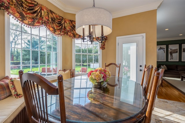 dining room with stone finish floor, ornamental molding, recessed lighting, and a chandelier