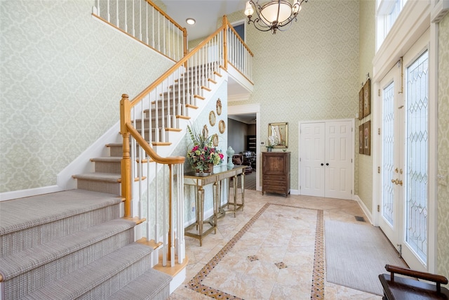 entryway featuring an inviting chandelier, recessed lighting, wallpapered walls, baseboards, and stairway