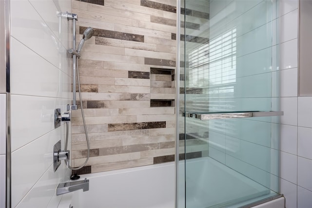 bathroom featuring combined bath / shower with glass door