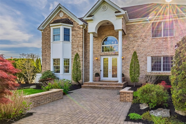 doorway to property featuring brick siding and french doors
