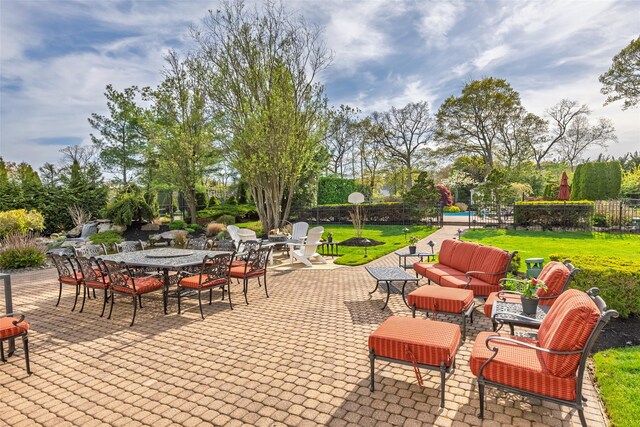 view of patio with a pool, fence, and outdoor dining space