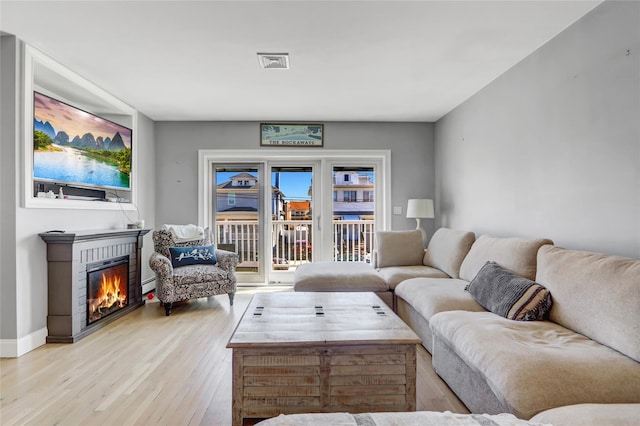 161 Bch 129th St, Rockaway Park, NY 11694 - living room featuring wood finished floors, a glass covered fireplace, and baseboards