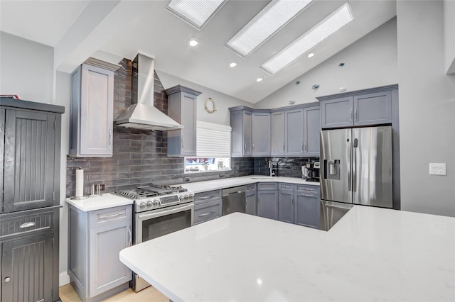161 Bch 129th St, Rockaway Park, NY 11694 - kitchen featuring appliances with stainless steel finishes, wall chimney range hood, light countertops, gray cabinets, and backsplash