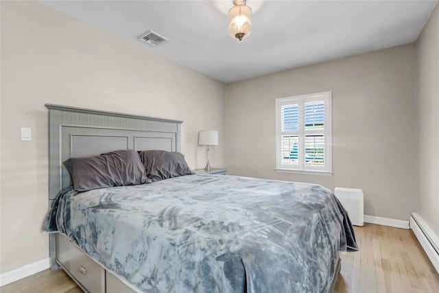 161 Bch 129th St, Rockaway Park, NY 11694 - bedroom featuring baseboard heating, baseboards, and light wood-style floors