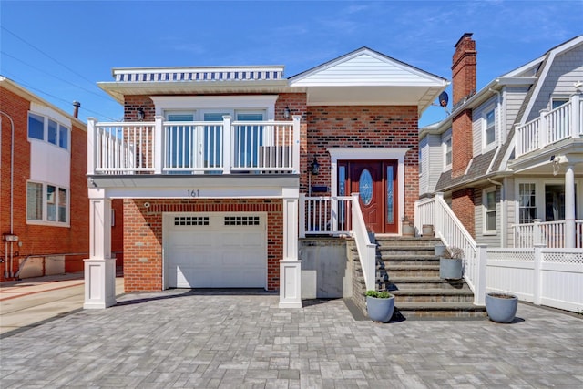161 Bch 129th St, Rockaway Park, NY 11694 - view of front of home with brick siding, a garage, a balcony, and driveway
