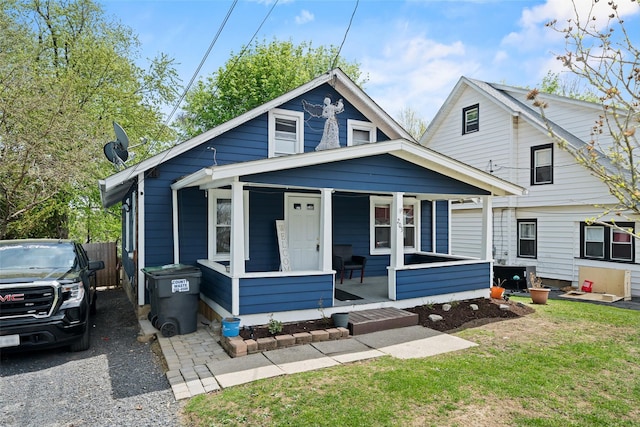 bungalow with a porch and a front lawn