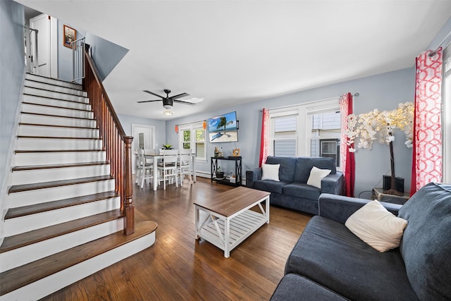 living room with stairs, a ceiling fan, baseboards, and wood finished floors