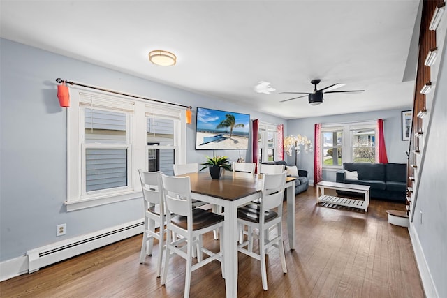 dining area with baseboards, a baseboard radiator, ceiling fan, and wood finished floors